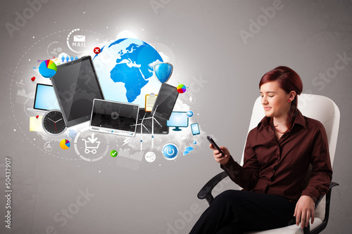 Photo: young woman sitting and browsing on her phone young woman sitting and browsing on her phone