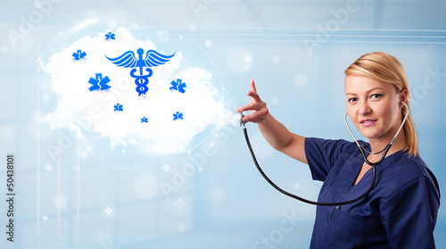 Photo: Young doctor with abstract cloud and medical icons Young doctor with abstract cloud and medical icons