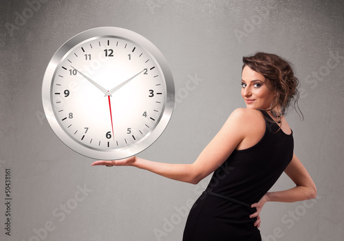 Photo: Attractive lady holding a huge clock Attractive lady holding a huge clock