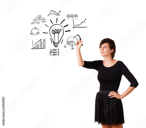 Photo: Young business woman drawing light bulb with various diagrams an Young business woman drawing light bulb with various diagrams an