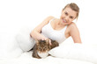 smiling young woman relaxing in white bedding