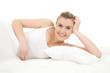 smiling beautiful girl relaxing in white bedding