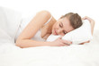beautiful young woman sleeping in white bedding