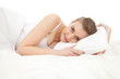 beautiful young woman lying in white bedding