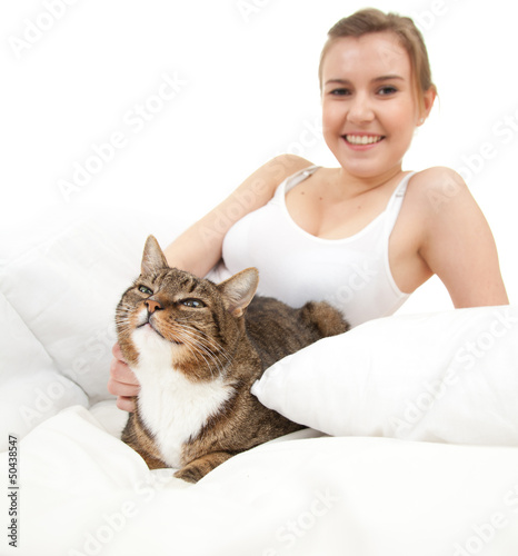 Photo: beautiful young woman with cat relaxing in white bedding beautiful young woman with cat relaxing in white bedding