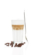 latte macchiato mit stehendem löffel und kaffeebohnen