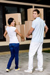 Back view of happy couple carrying cardboard containers