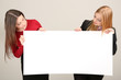 Two business women with blank form on grey background