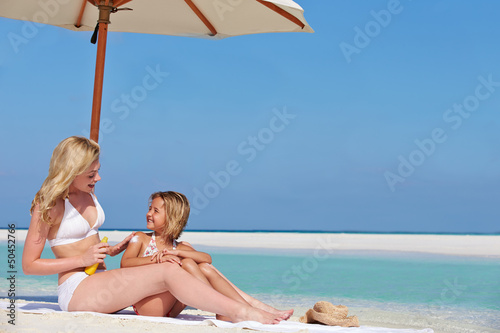 Photo: Mother Protecting Daughter With Sun Lotion On Beach Holiday Mother Protecting Daughter With Sun Lotion On Beach Holiday