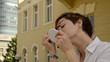 Young woman paints her eyebrows and eyelashes outdoors