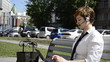 Business woman talking through a headset, sitting on a bench