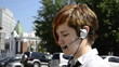 Business woman says through the headset outside