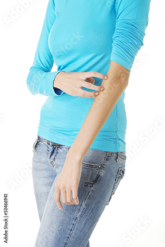 Photo: Young woman scratching her self. Young woman scratching her self.