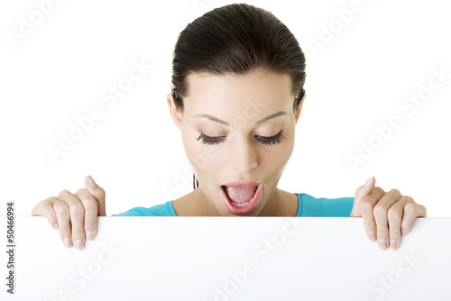 Photo: Shocked woman holding blank board Shocked woman holding blank board
