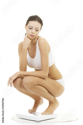 Photo: Frustrated woman on scale Frustrated woman on scale