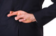 Business man with fingers crossed.