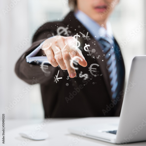 Photo: Investment concept. Handsome business man with currency symbols. Investment concept. Handsome business man with currency symbols.