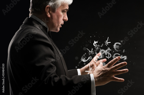 Photo: Investment concept. Handsome business man with currency symbols. Investment concept. Handsome business man with currency symbols.