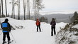 Young woman photographing skiers on a mountain top