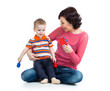 Mother and baby boy having fun with musical toys. Isolated on wh