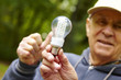 Photo: Senior man showing eco diode bulb Senior man showing eco diode bulb