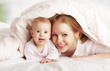happy family. Mother and baby playing under  blanket