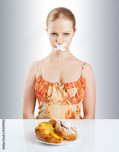 Photo: diet concept. woman mouth sealed with duct tape with buns diet concept. woman mouth sealed with duct tape with buns