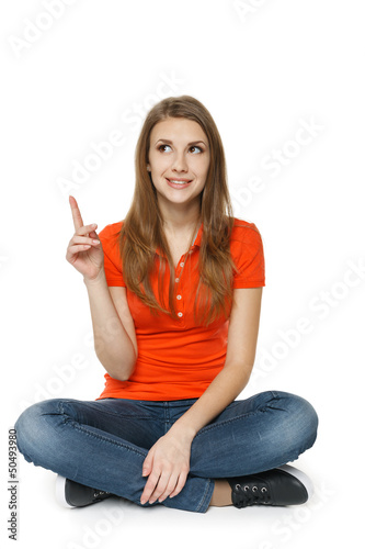 Photo: Happy female sitting on the floor, pointing and looking up Happy female sitting on the floor, pointing and looking up