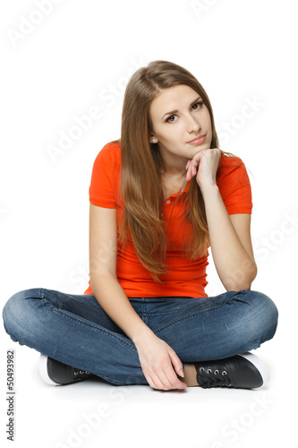 Photo: Calm woman sitting on the floor with chin on hand Calm woman sitting on the floor with chin on hand