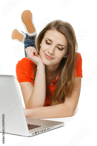 Photo: Front view of female lying on the floor with laptop Front view of female lying on the floor with laptop