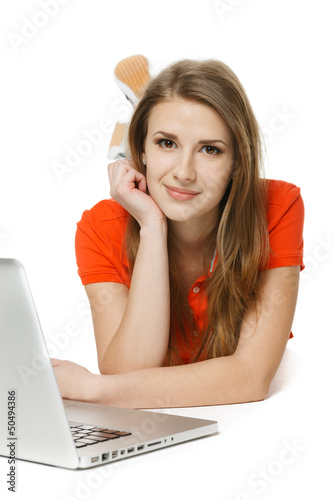 Photo: Front view of female lying on the floor with laptop Front view of female lying on the floor with laptop
