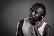 Foto: African man with ear-phones isolated on dark background. African man with ear-phones isolated on dark background.
