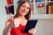 Photo: woman holding tablet pc and showing thumbs up woman holding tablet pc and showing thumbs up