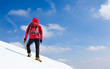Mountaineer walking uphill along a snowy slope.
