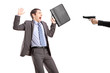 Scared businessman from a hand holding a gun