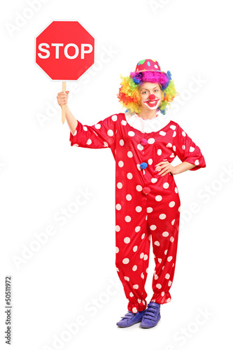 Photo: Full length portrait of a clown holding a stop sign Full length portrait of a clown holding a stop sign