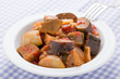 Cooked stewed eggplants in plate close-up served on linen napkin