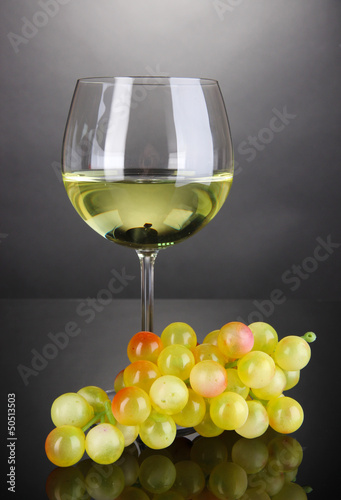 Photo: White wine glass on grey background White wine glass on grey background