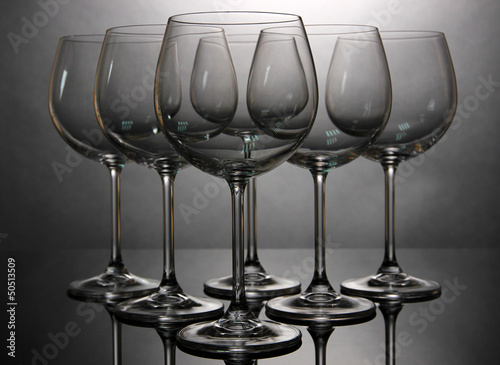 Photo: Empty wine glasses arranged on grey background Empty wine glasses arranged on grey background