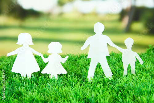 Photo: Paper people on green grass on bright background Paper people on green grass on bright background