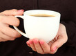 Hands holding mug of hot drink, close-up