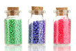 Little bottles full with colorful beads isolated on white