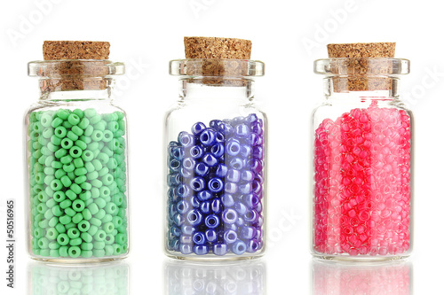 Photo: Little bottles full with colorful beads isolated on white Little bottles full with colorful beads isolated on white