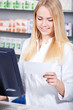 Apothekerin prüft Rezept auf Verfügbarkeit
