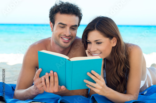Photo: Couple Reading Book At The Beach Couple Reading Book At The Beach