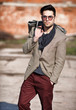 sexy fashion man model dressed elegant holding a bag posing outd