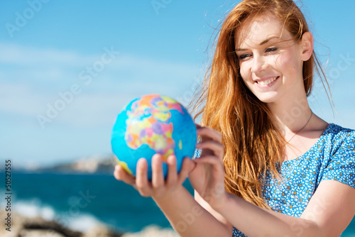 Photo: junge frau mit globus am meer junge frau mit globus am meer