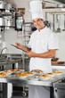 Male Chef With Clipboard At Kitchen