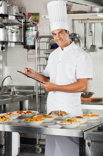 Photo: Male Chef With Clipboard At Kitchen Male Chef With Clipboard At Kitchen
