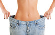 Woman shows her weight loss by wearing an old jeans, isolated on